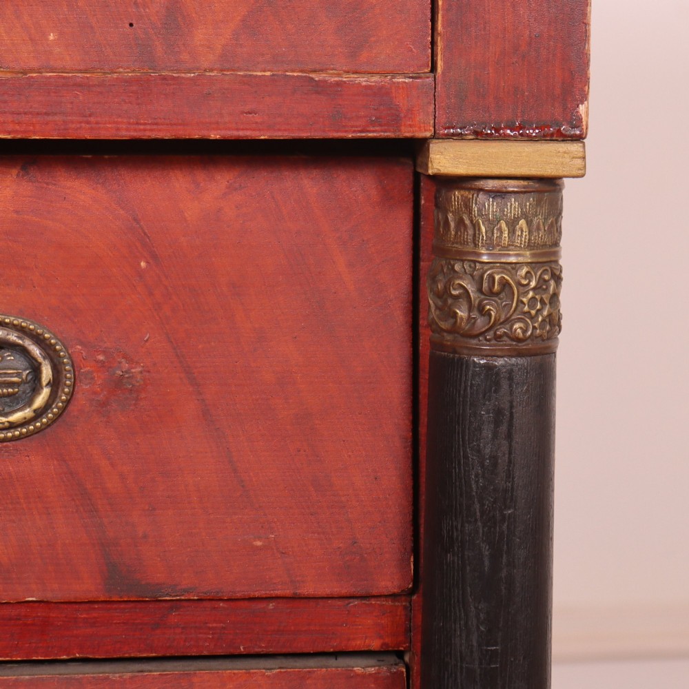 A Dutch Empire style red mahogany commode with four drawers, ebonised side columns, and round brass handles. View VI