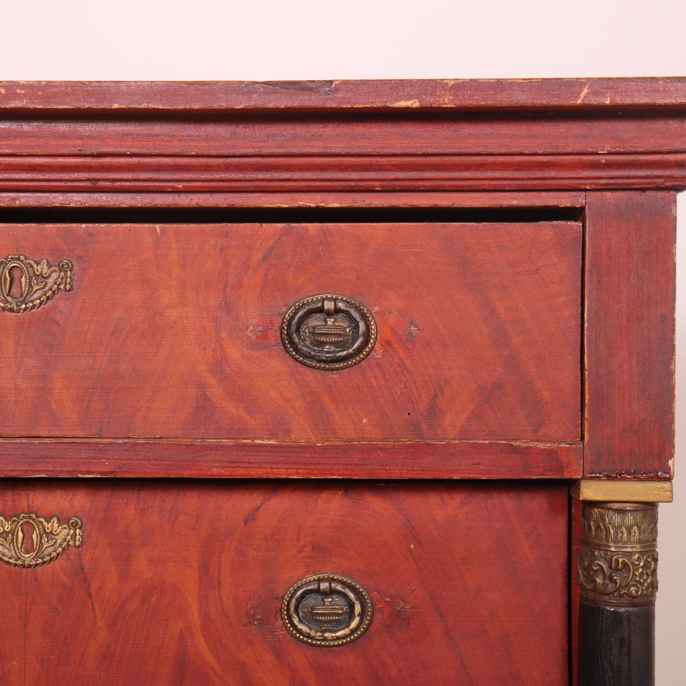 A Dutch Empire style red mahogany commode with four drawers, ebonised side columns, and round brass handles. View VII