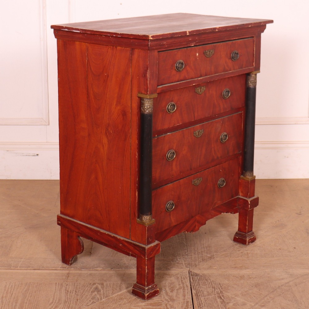 A Dutch Empire style red mahogany commode with four drawers, ebonised side columns, and round brass handles. View VIII