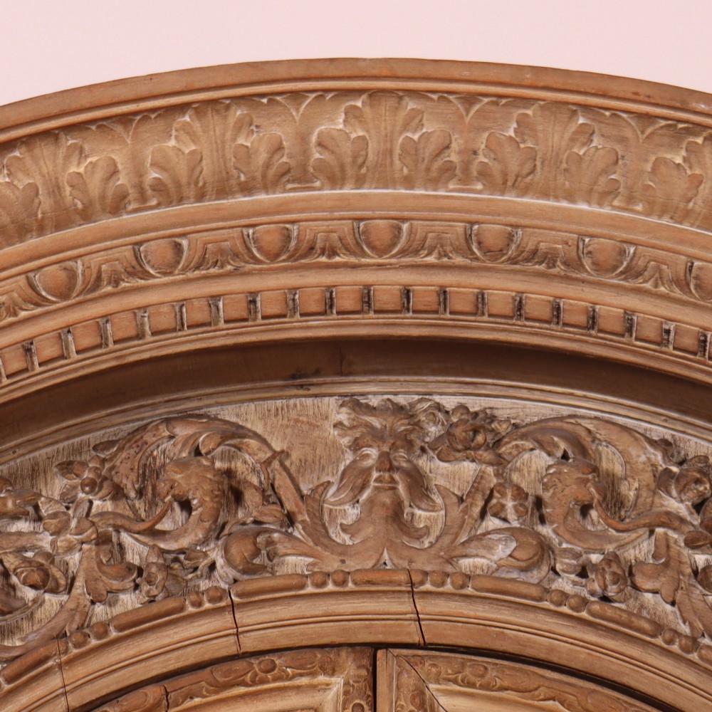 A large Italian carved wood vitrine featuring arched upper glazed doors lined with fabric, flanked by caryatid figures and intricate relief panels. View III