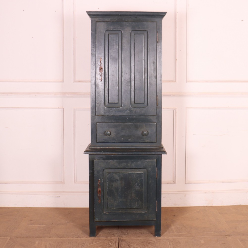 A tall, narrow antique French provincial food cupboard in a dark grey painted finish, featuring recessed upper panels, a central drawer, and a lower single-door cabinet.