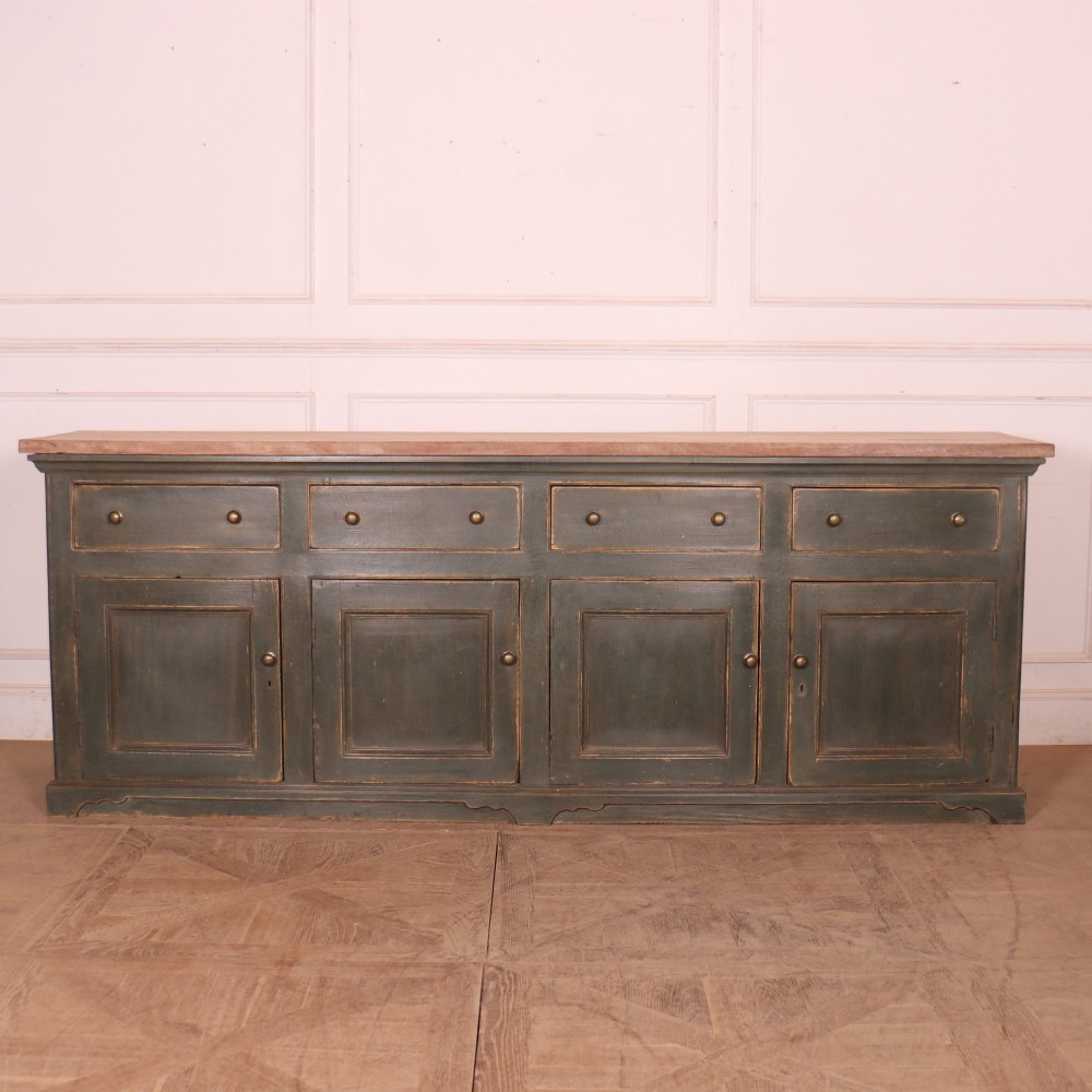 A long dark green painted wooden dresser base featuring four upper drawers over four panelled cupboard doors with a natural timber top.