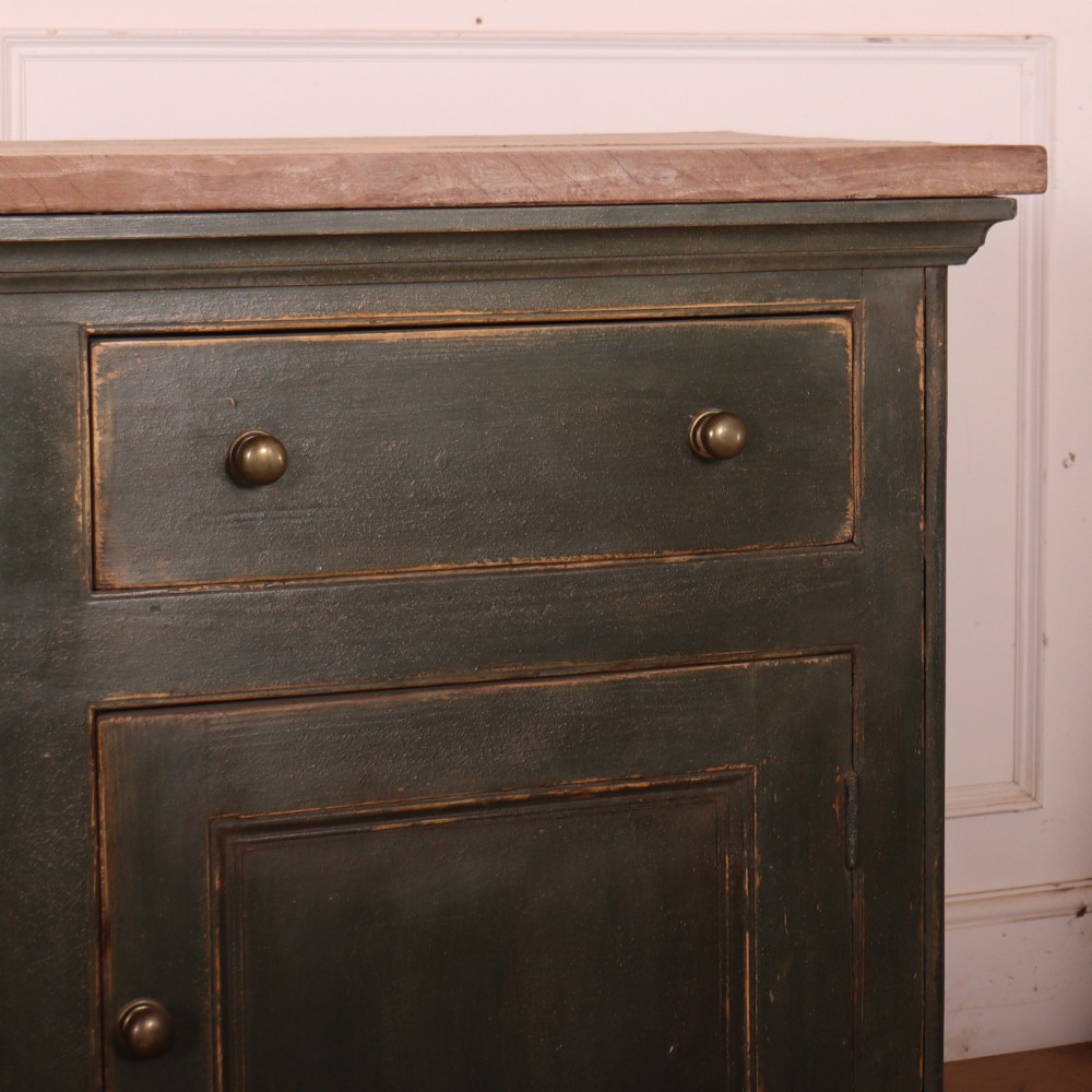 A long dark green painted wooden dresser base featuring four upper drawers over four panelled cupboard doors with a natural timber top. View IV