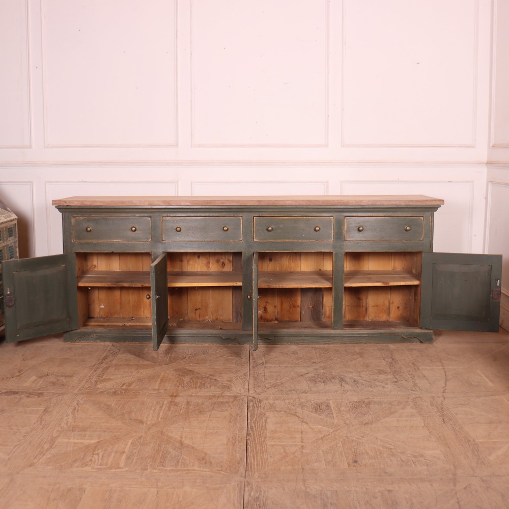A long dark green painted wooden dresser base featuring four upper drawers over four panelled cupboard doors with a natural timber top. View VII