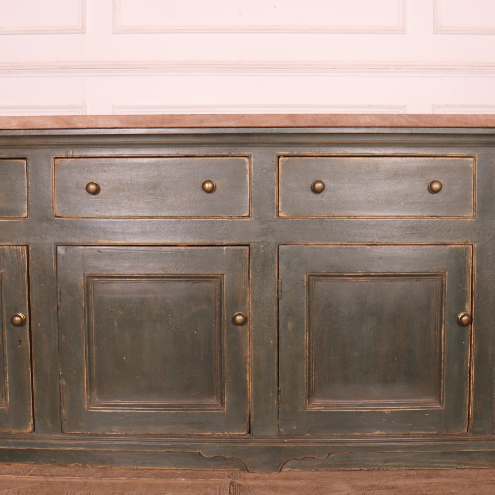 A long dark green painted wooden dresser base featuring four upper drawers over four panelled cupboard doors with a natural timber top. View VIII