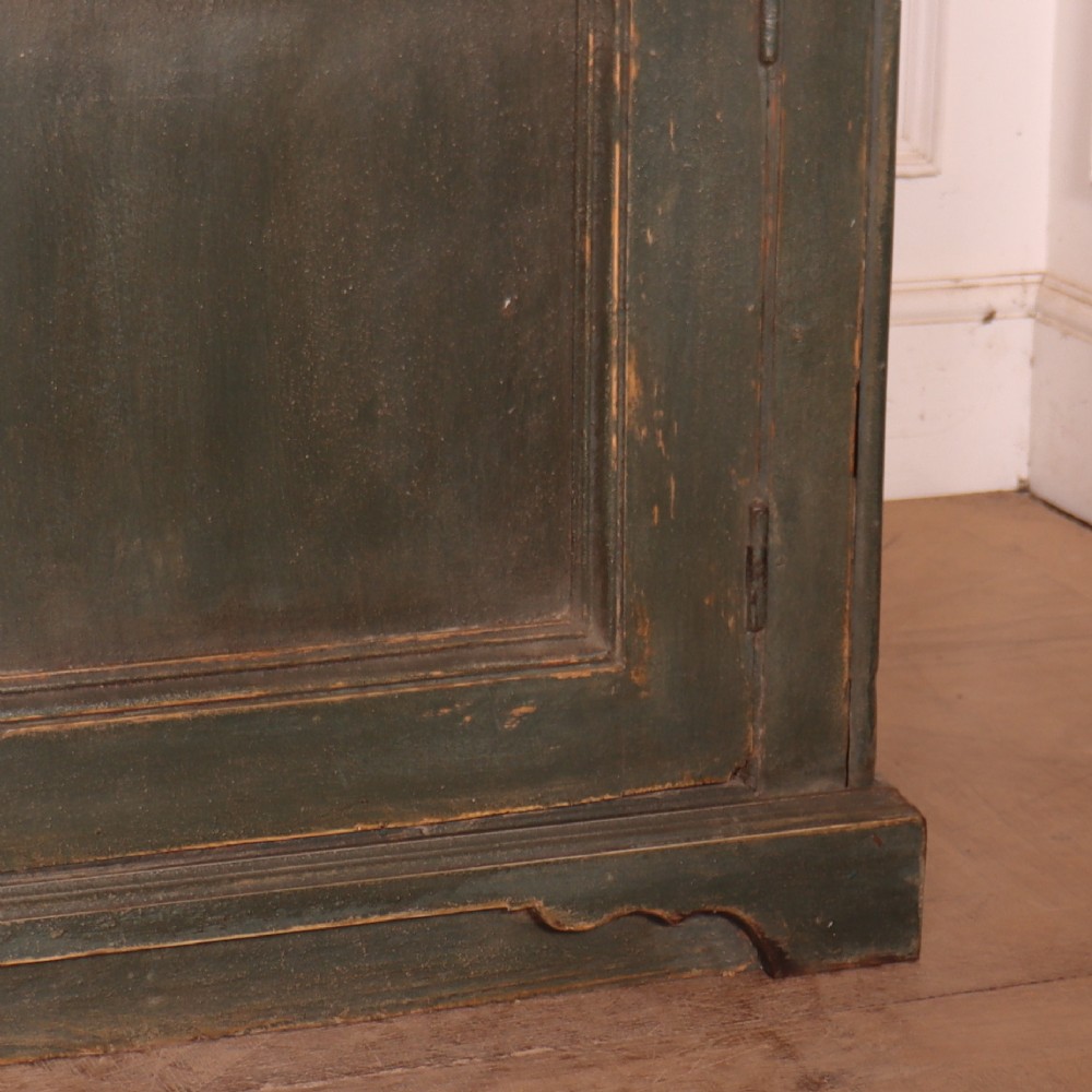 A long dark green painted wooden dresser base featuring four upper drawers over four panelled cupboard doors with a natural timber top. View X