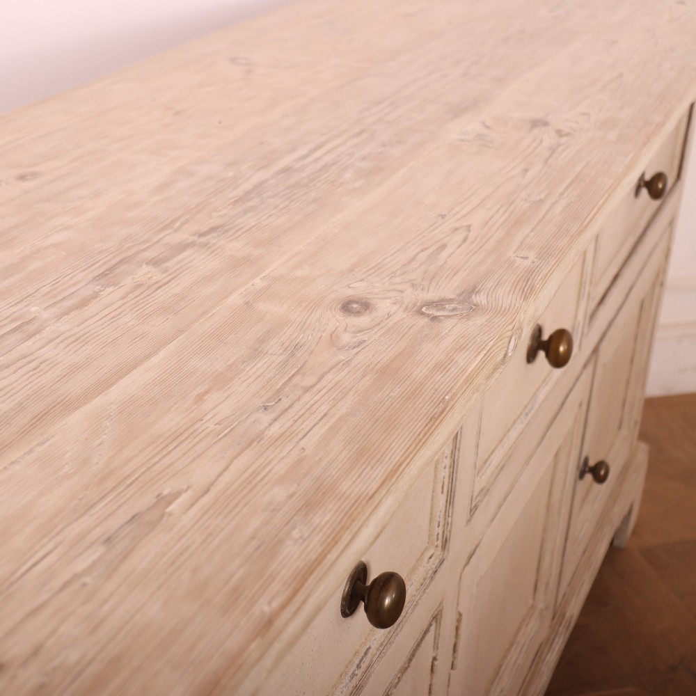 A large off-white painted English dresser base featuring four drawers above four cupboard doors with small brass knob handles. View XIII