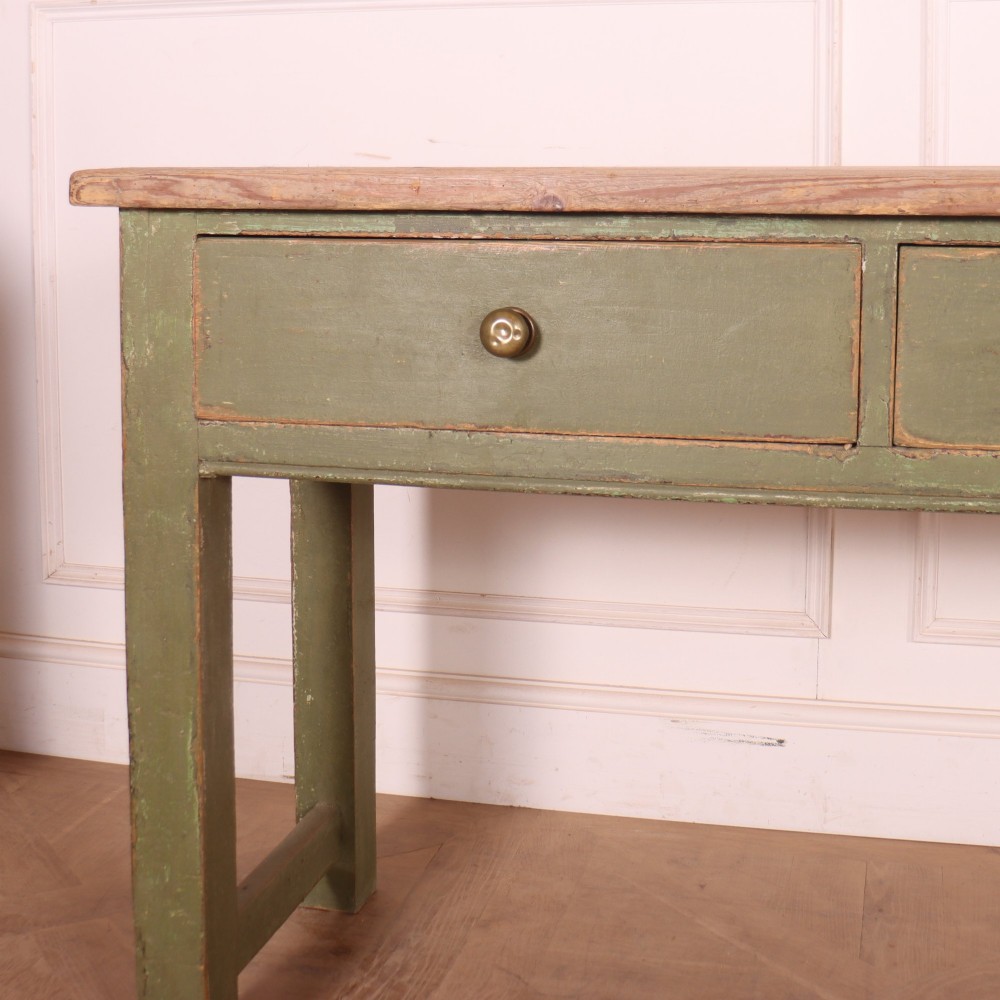 A long antique painted dresser base with four inline drawers, small brass knobs, a green frame, and a scrubbed wooden top. View II
