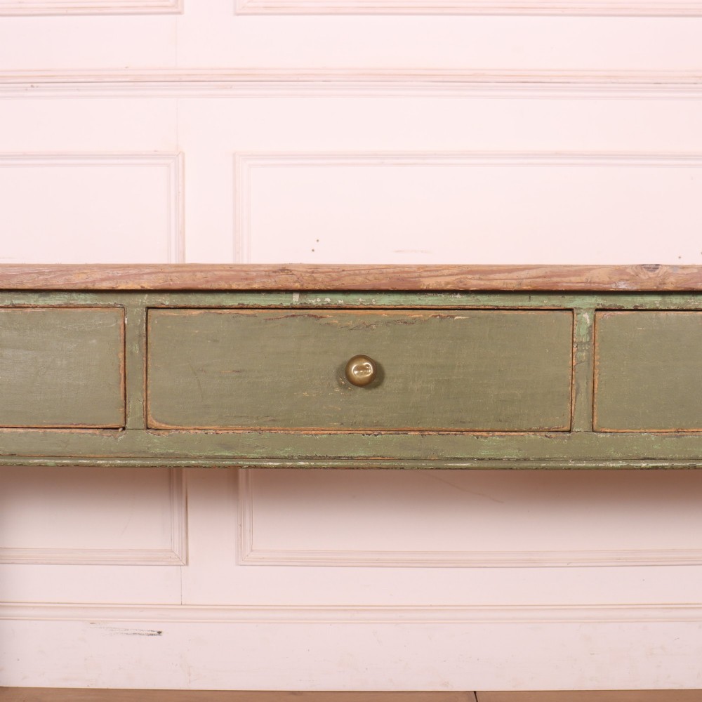 A long antique painted dresser base with four inline drawers, small brass knobs, a green frame, and a scrubbed wooden top. View VI