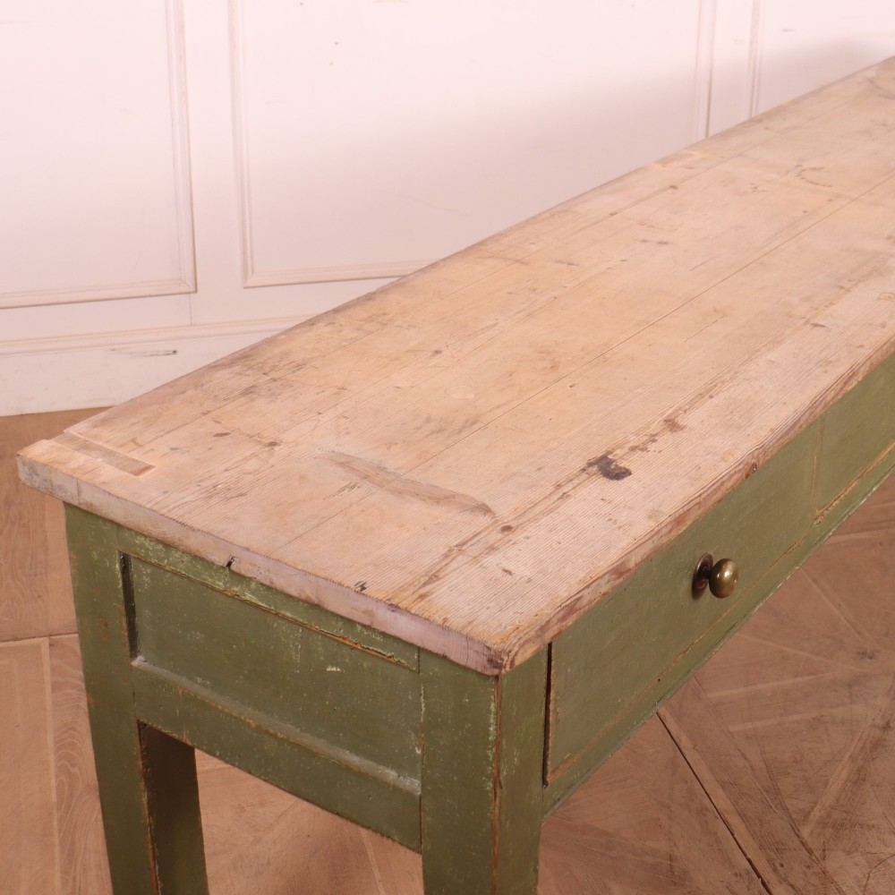 A long antique painted dresser base with four inline drawers, small brass knobs, a green frame, and a scrubbed wooden top. View IX