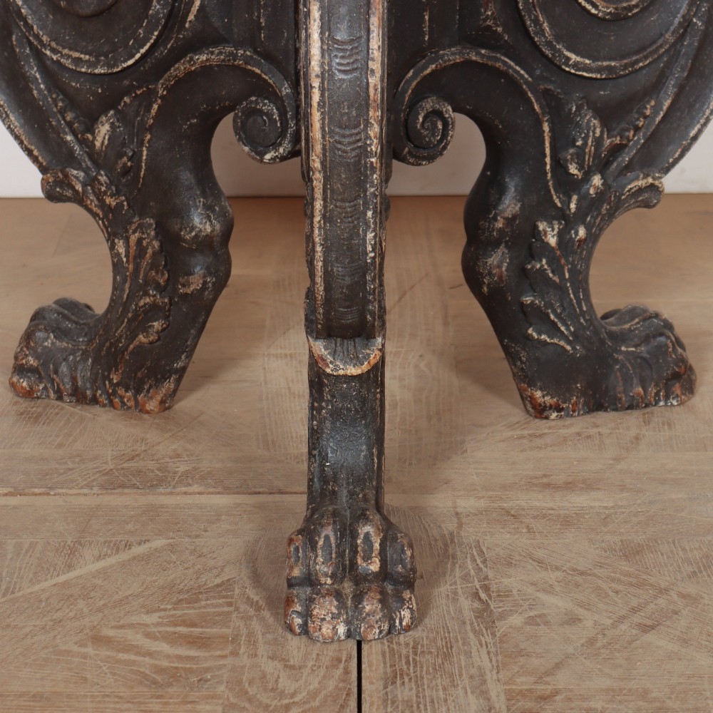 An antique round side table with a cream and grey circular checkerboard top supported by dark carved scroll legs with paw feet. View IV