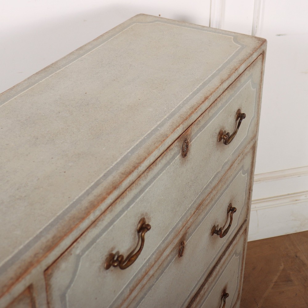 A wide pale grey painted chest featuring six drawers decorated with blue painted border outlines and brass drop handles. View XI