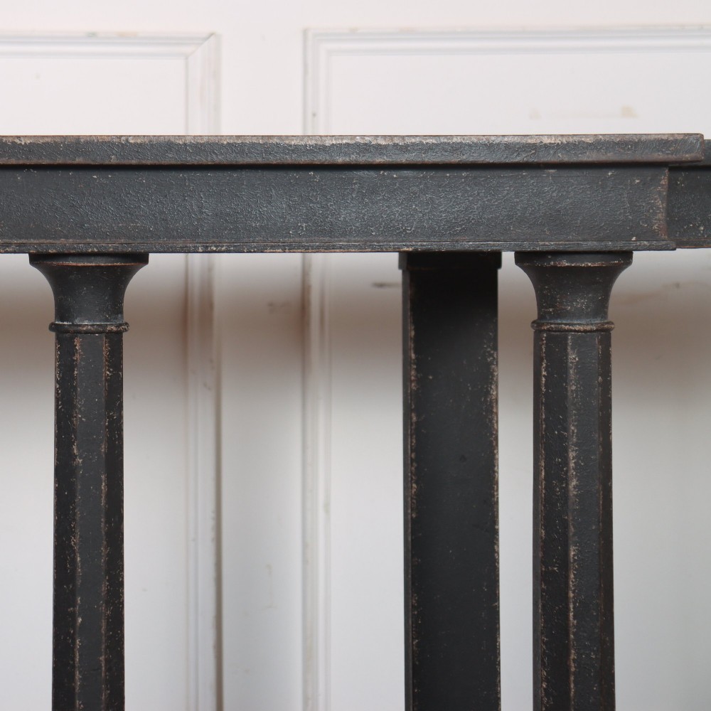 A long black painted beech console table featuring turned column legs and a solid plinth base. View VII
