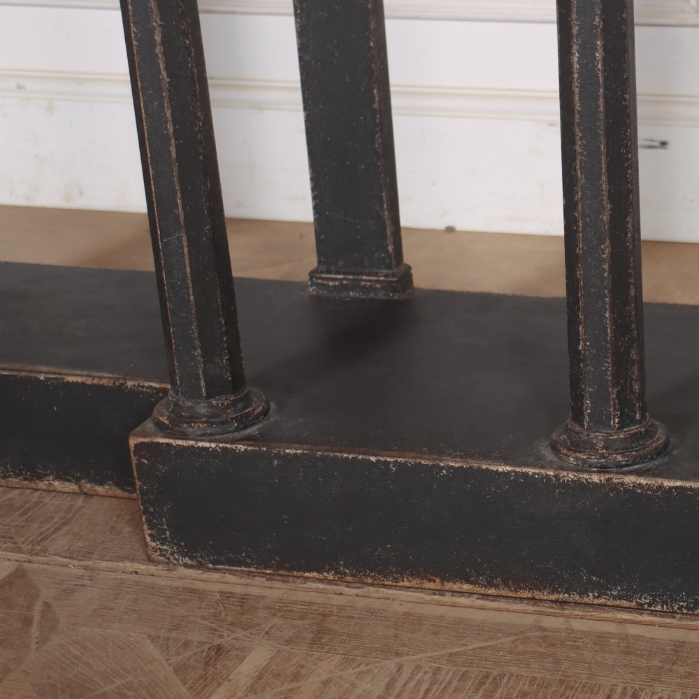 A long black painted beech console table featuring turned column legs and a solid plinth base. View VIII