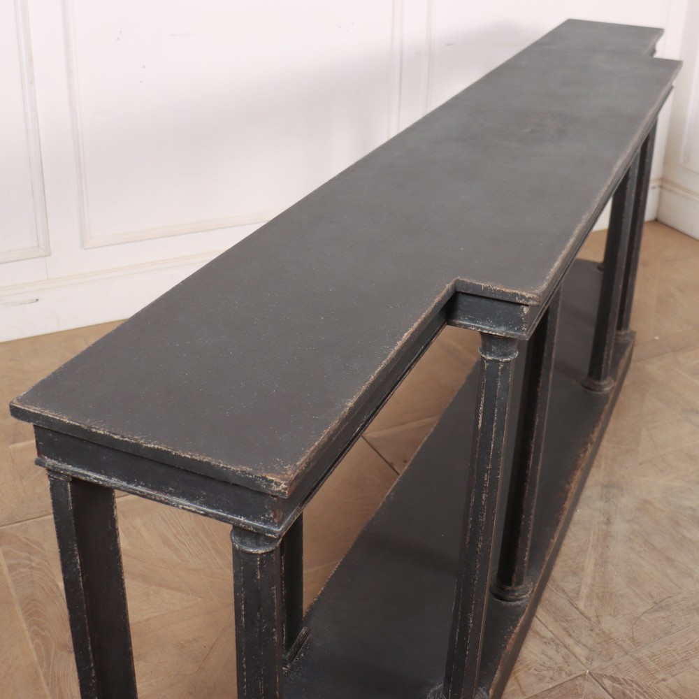 A long black painted beech console table featuring turned column legs and a solid plinth base. View IX