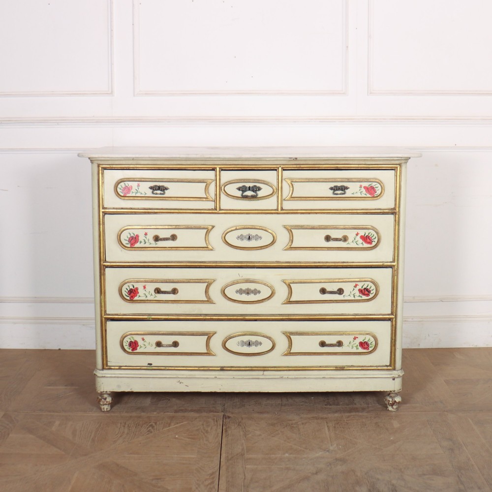 A 19th-century Spanish painted commode in cream featuring hand-painted red floral accents, gilded drawer mouldings, and brass handles.