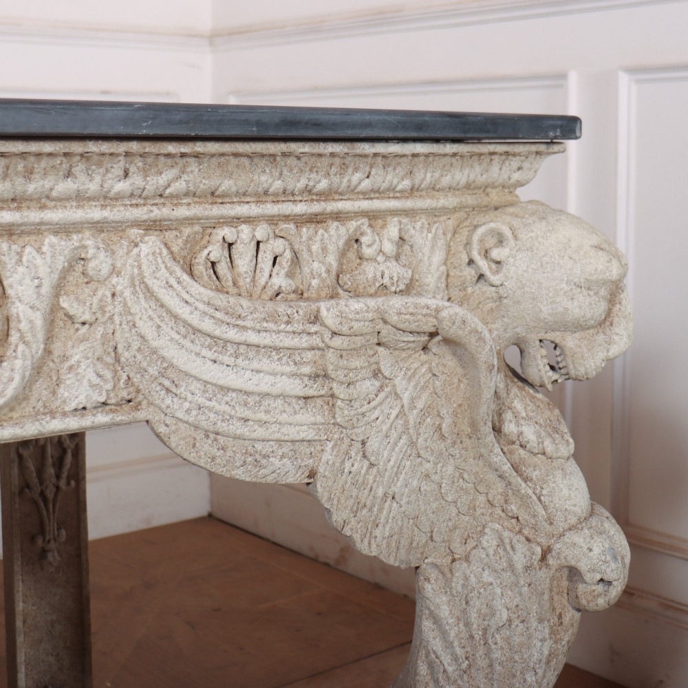 A pair of large off-white painted console tables featuring carved winged lion monopodium supports, anthemion friezes, and dark grey tops. View IX