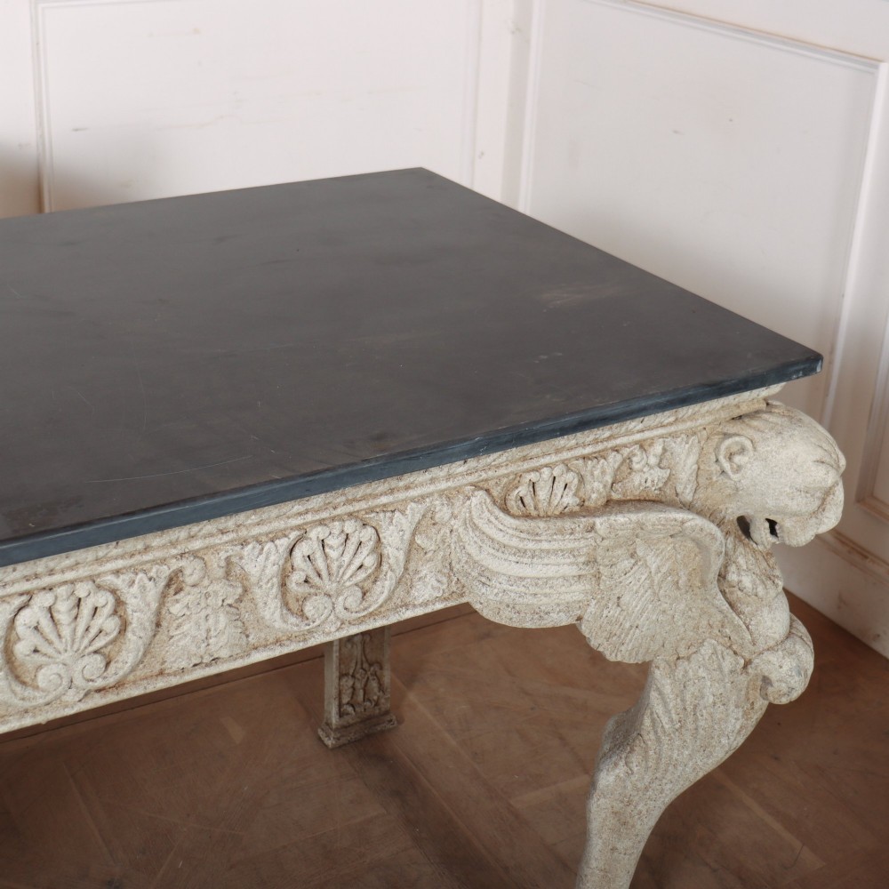 A pair of large off-white painted console tables featuring carved winged lion monopodium supports, anthemion friezes, and dark grey tops. View XI