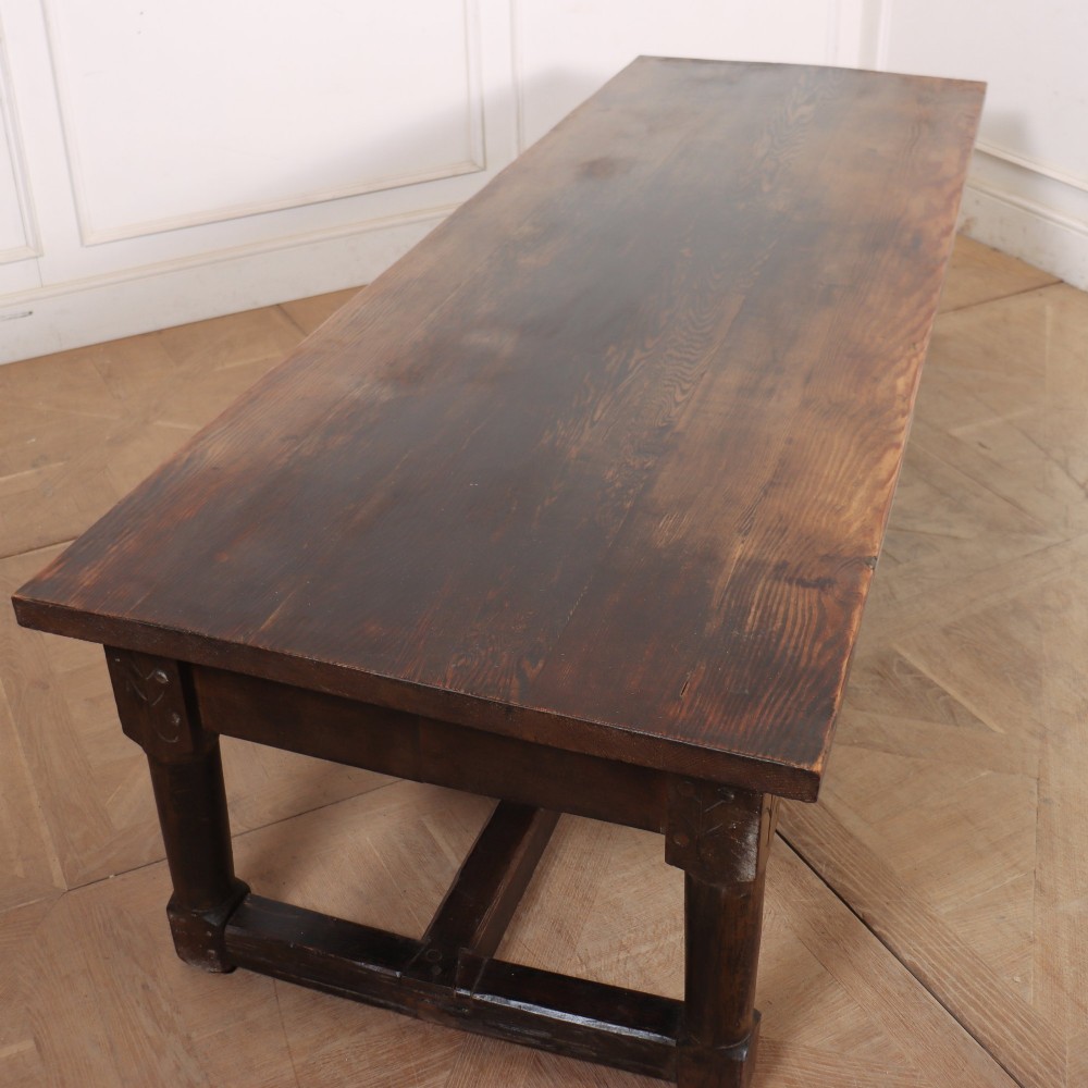 A long, dark oak low coffee table featuring hand-carved frieze panels and square legs joined by a low stretcher base. View V