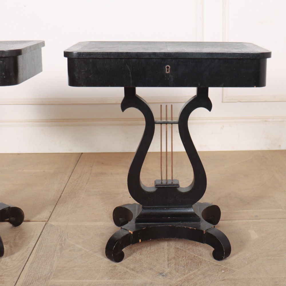 A pair of black ebonised side tables featuring single drawers with brass keyholes and lyre-shaped pedestal bases resting on scroll feet. View III