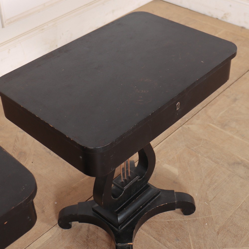 A pair of black ebonised side tables featuring single drawers with brass keyholes and lyre-shaped pedestal bases resting on scroll feet. View VII