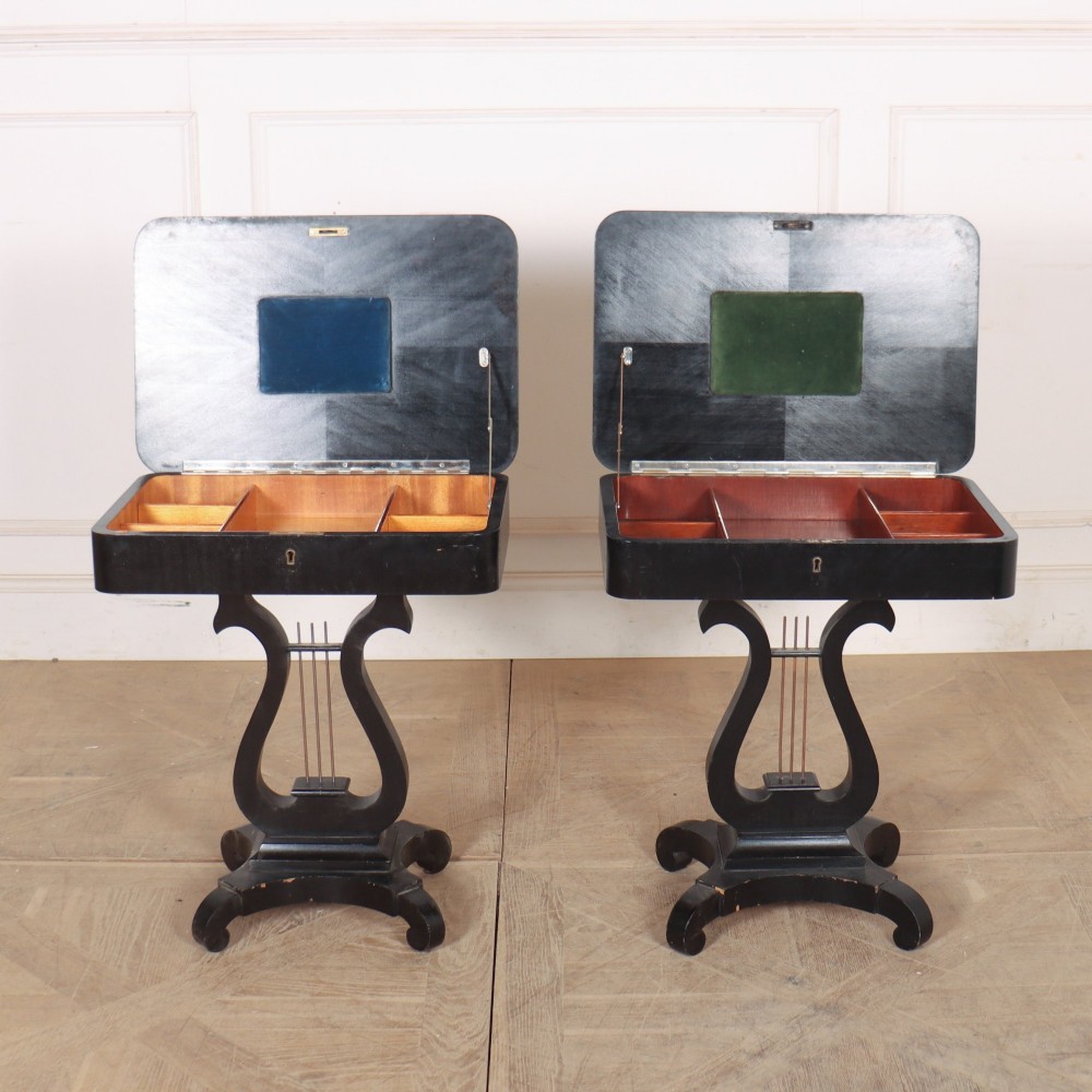 A pair of black ebonised side tables featuring single drawers with brass keyholes and lyre-shaped pedestal bases resting on scroll feet. View VIII