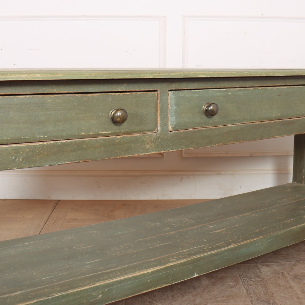 A long, green painted timber potboard serving table featuring two wide drawers with small round knobs and a continuous open shelf below. View IV