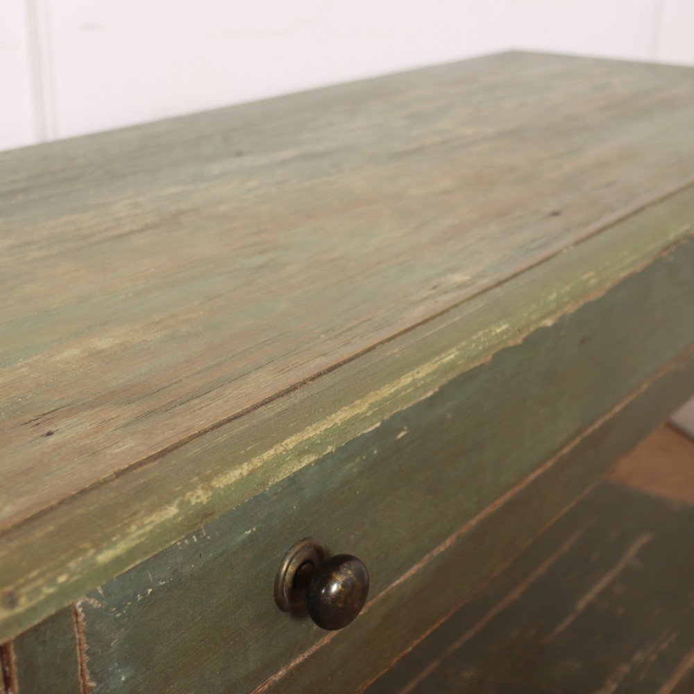A long, green painted timber potboard serving table featuring two wide drawers with small round knobs and a continuous open shelf below. View X