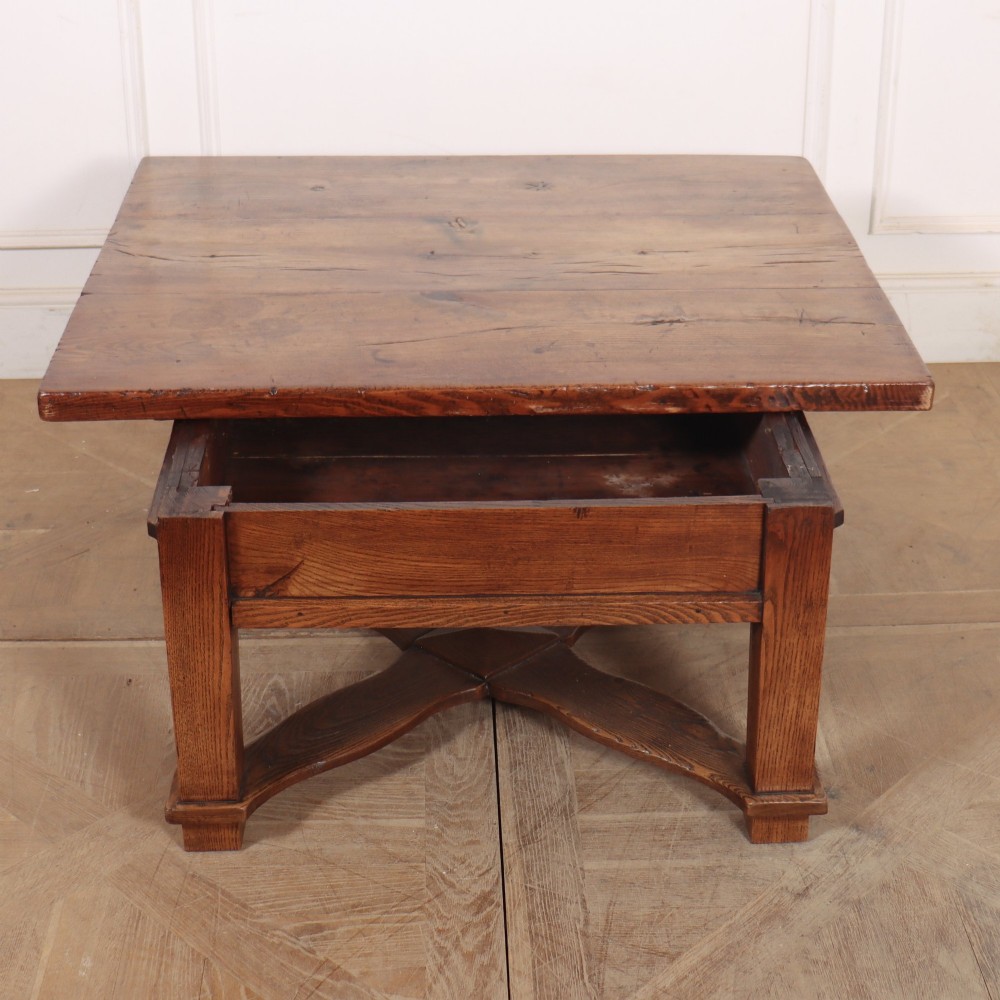 A square, low-profile coffee table crafted from solid brown elm featuring straight legs and an X-shaped cross-stretcher base. View VII