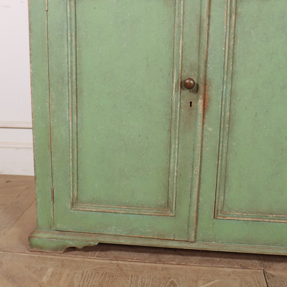 A two-part antique green painted wood kitchen dresser featuring a three-door glazed upper cabinet and three panelled cupboard doors below. View IV