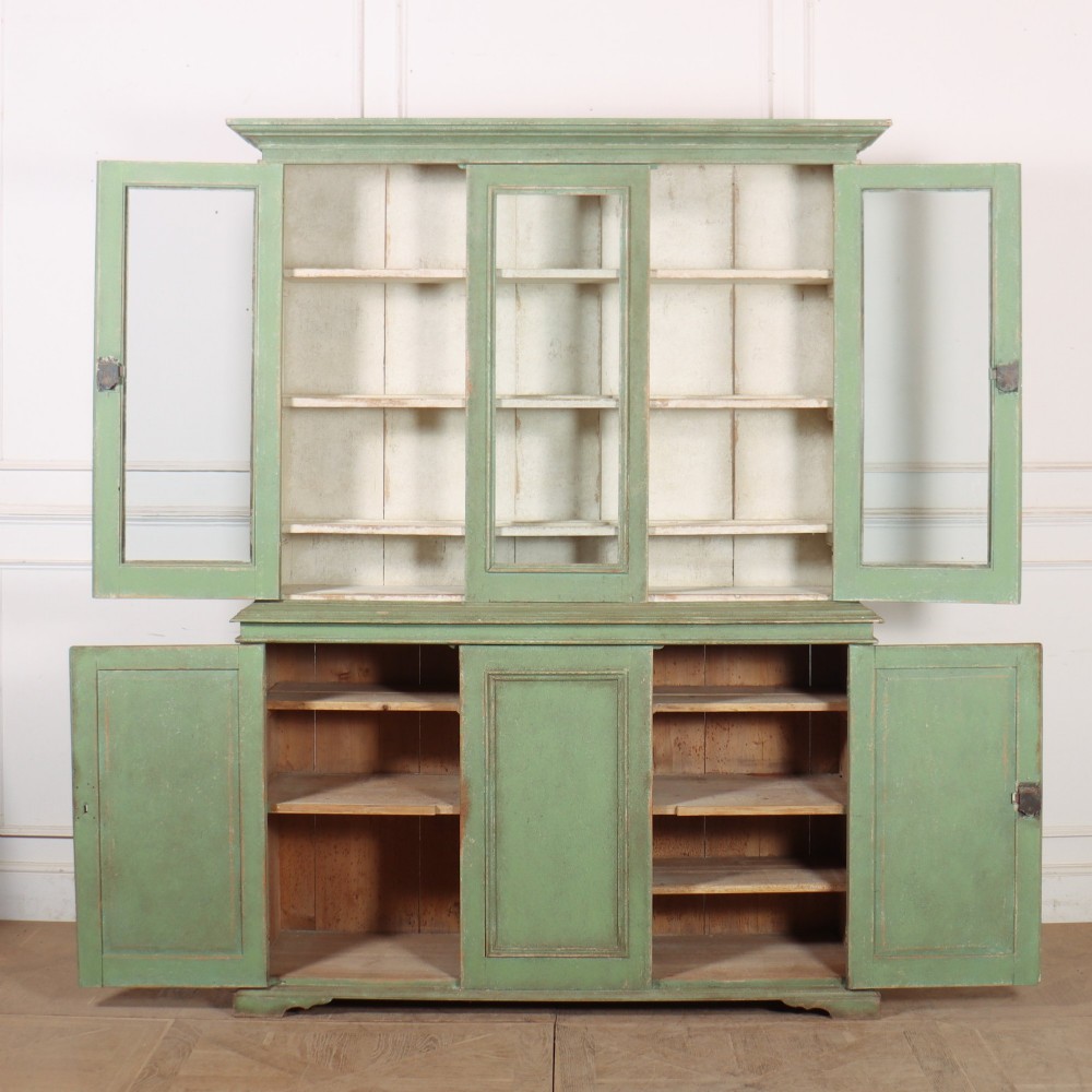 A two-part antique green painted wood kitchen dresser featuring a three-door glazed upper cabinet and three panelled cupboard doors below. View X