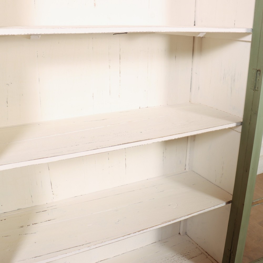 A tall 19th-century English painted sage green glazed display bookcase with two glass panel doors and an off-white interior. View VIII