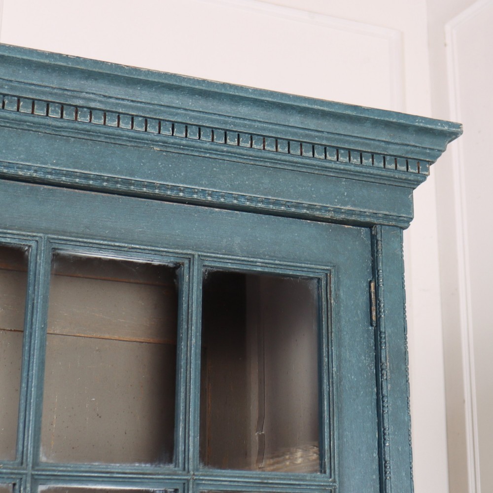 A pair of tall English glazed library bookcases painted in a muted teal blue finish with contrasting light interior shelves and glass grid doors. View III