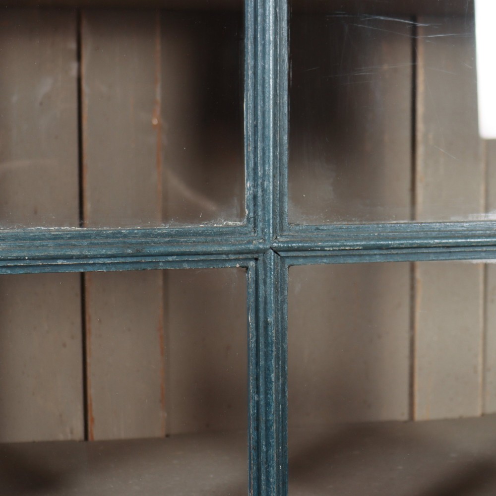 A pair of tall English glazed library bookcases painted in a muted teal blue finish with contrasting light interior shelves and glass grid doors. View VI