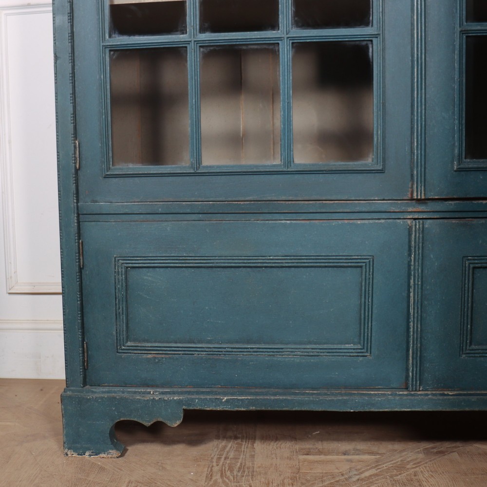 A pair of tall English glazed library bookcases painted in a muted teal blue finish with contrasting light interior shelves and glass grid doors. View XIII