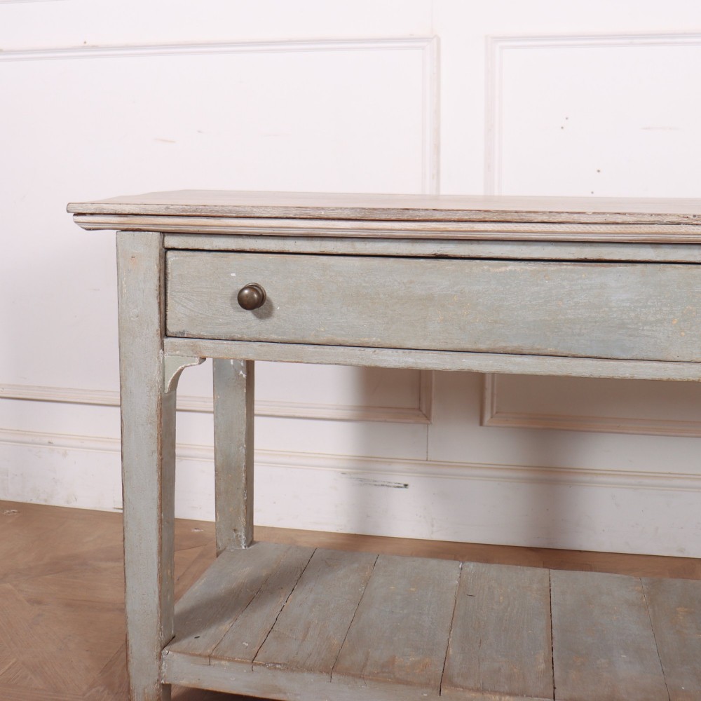 An English painted wooden potboard dresser base with a scrubbed timber top, two drawers, turned legs, and an open slatted lower shelf. View II