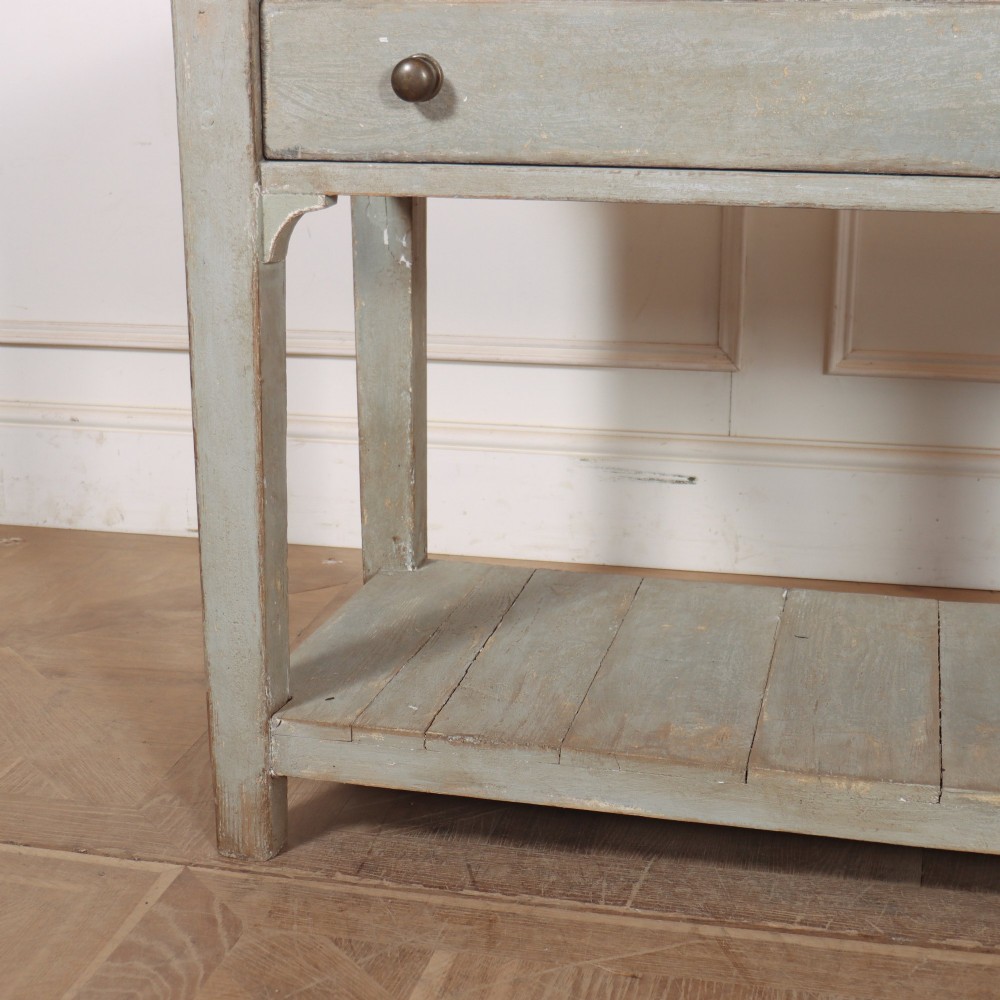 An English painted wooden potboard dresser base with a scrubbed timber top, two drawers, turned legs, and an open slatted lower shelf. View III