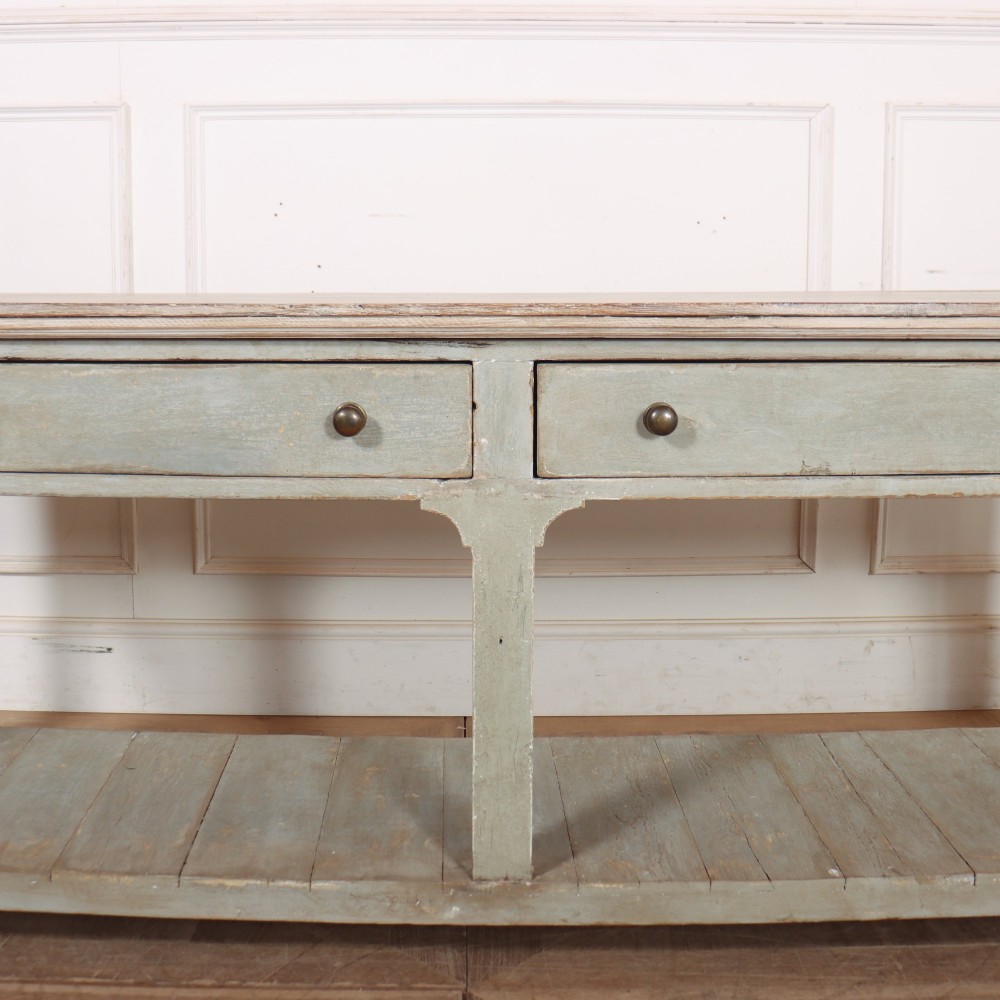 An English painted wooden potboard dresser base with a scrubbed timber top, two drawers, turned legs, and an open slatted lower shelf. View IV
