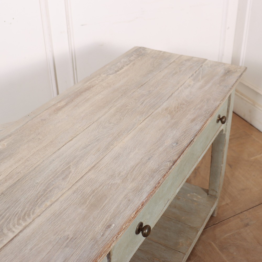 An English painted wooden potboard dresser base with a scrubbed timber top, two drawers, turned legs, and an open slatted lower shelf. View X