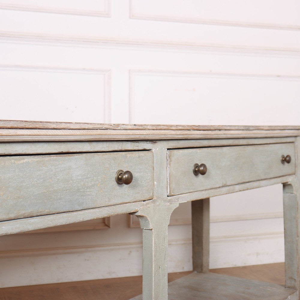 An English painted wooden potboard dresser base with a scrubbed timber top, two drawers, turned legs, and an open slatted lower shelf. View XI