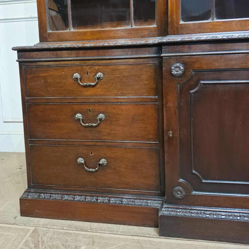 A large dark mahogany breakfront bookcase featuring astragal glazed upper doors, lower drawers, and a central cupboard door. View II