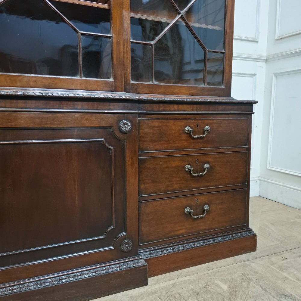 A large dark mahogany breakfront bookcase featuring astragal glazed upper doors, lower drawers, and a central cupboard door. View III