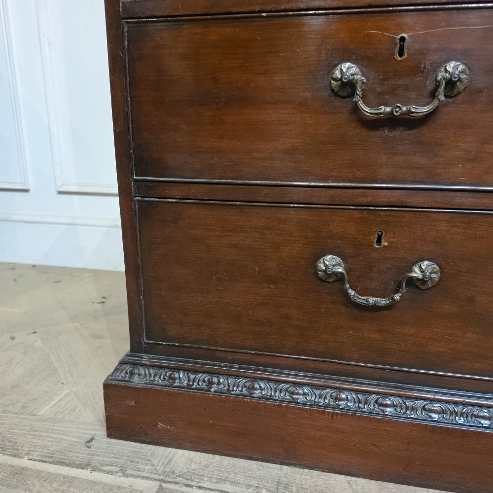 A large dark mahogany breakfront bookcase featuring astragal glazed upper doors, lower drawers, and a central cupboard door. View VIII