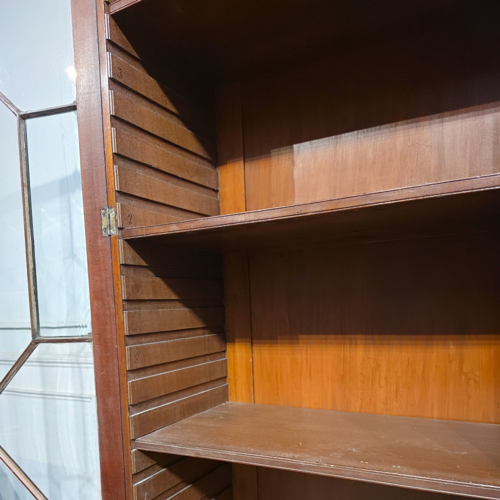 A large dark mahogany breakfront bookcase featuring astragal glazed upper doors, lower drawers, and a central cupboard door. View X