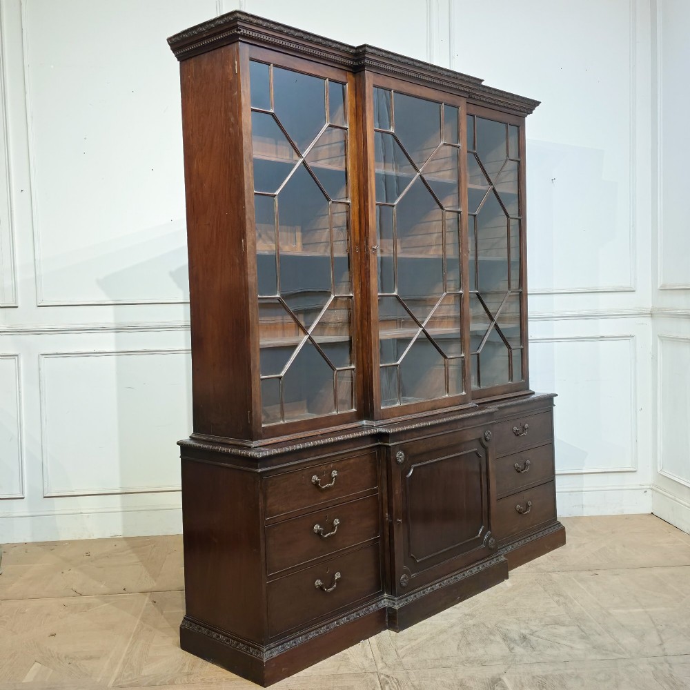 A large dark mahogany breakfront bookcase featuring astragal glazed upper doors, lower drawers, and a central cupboard door. View XII