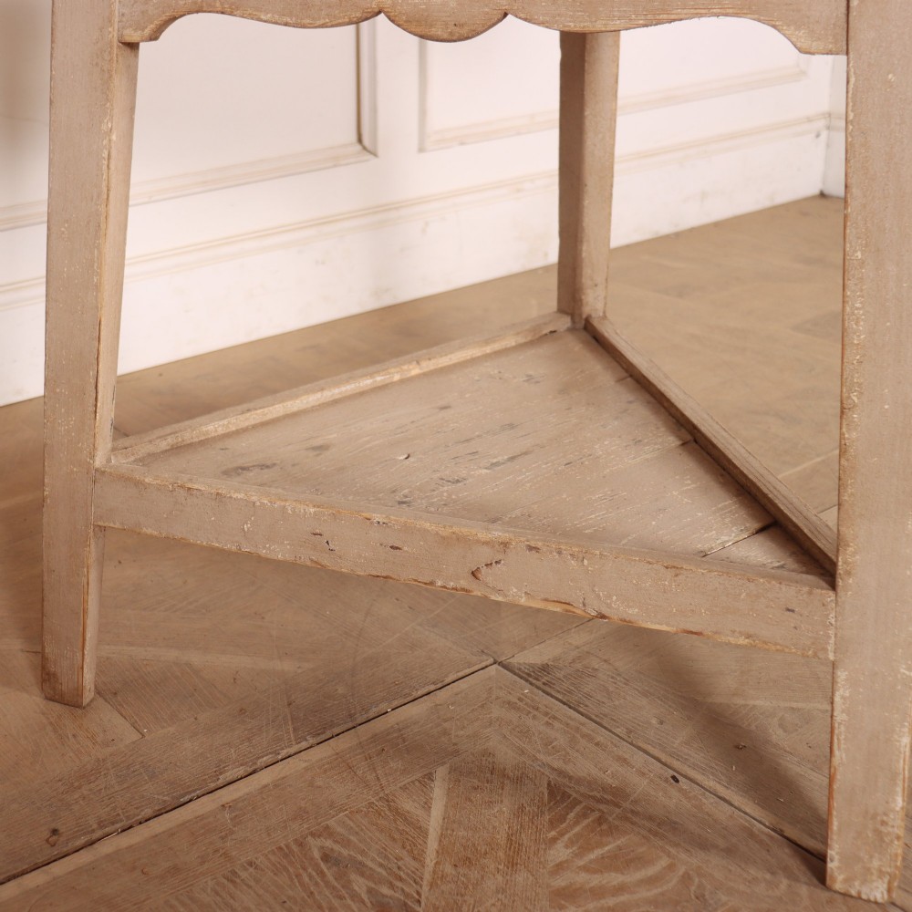 A nineteenth-century round wooden cricket table with three tapered legs, a lower triangular shelf, a scalloped apron, and a pale grey painted finish. View IV
