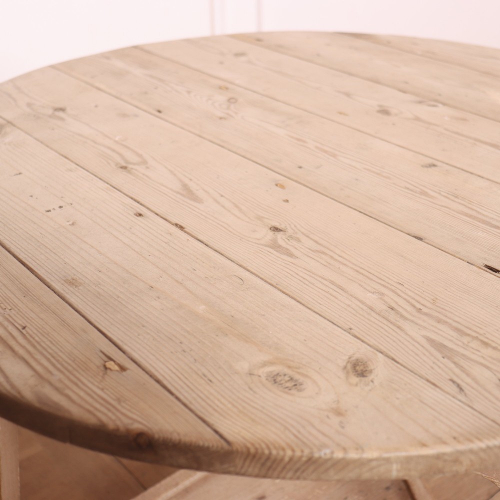 A nineteenth-century round wooden cricket table with three tapered legs, a lower triangular shelf, a scalloped apron, and a pale grey painted finish. View V