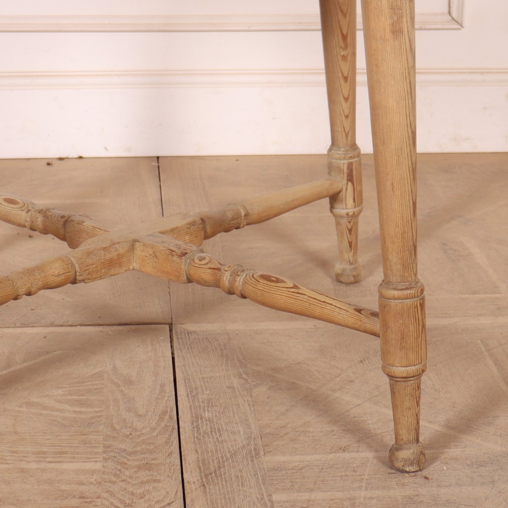 A 19th-century circular Welsh tavern table constructed from light pine with a frieze drawer, turned legs, and an X-frame stretcher. View III