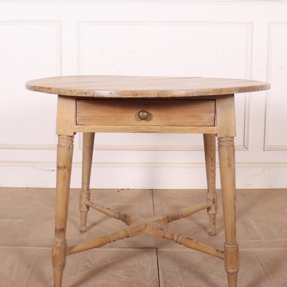 A 19th-century circular Welsh tavern table constructed from light pine with a frieze drawer, turned legs, and an X-frame stretcher. View IV