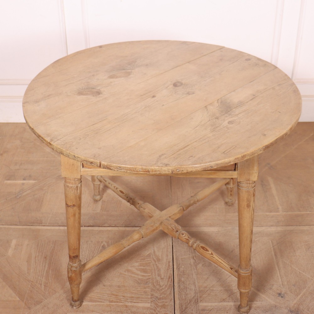 A 19th-century circular Welsh tavern table constructed from light pine with a frieze drawer, turned legs, and an X-frame stretcher. View V